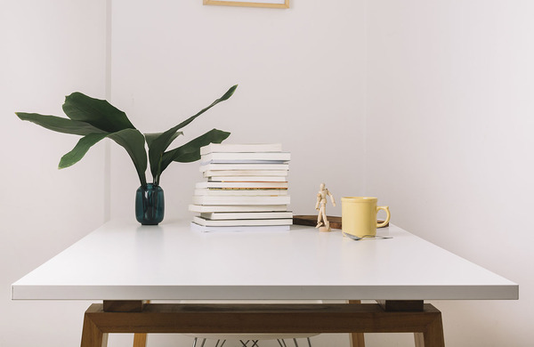Escritorio minimalista con taza y planta